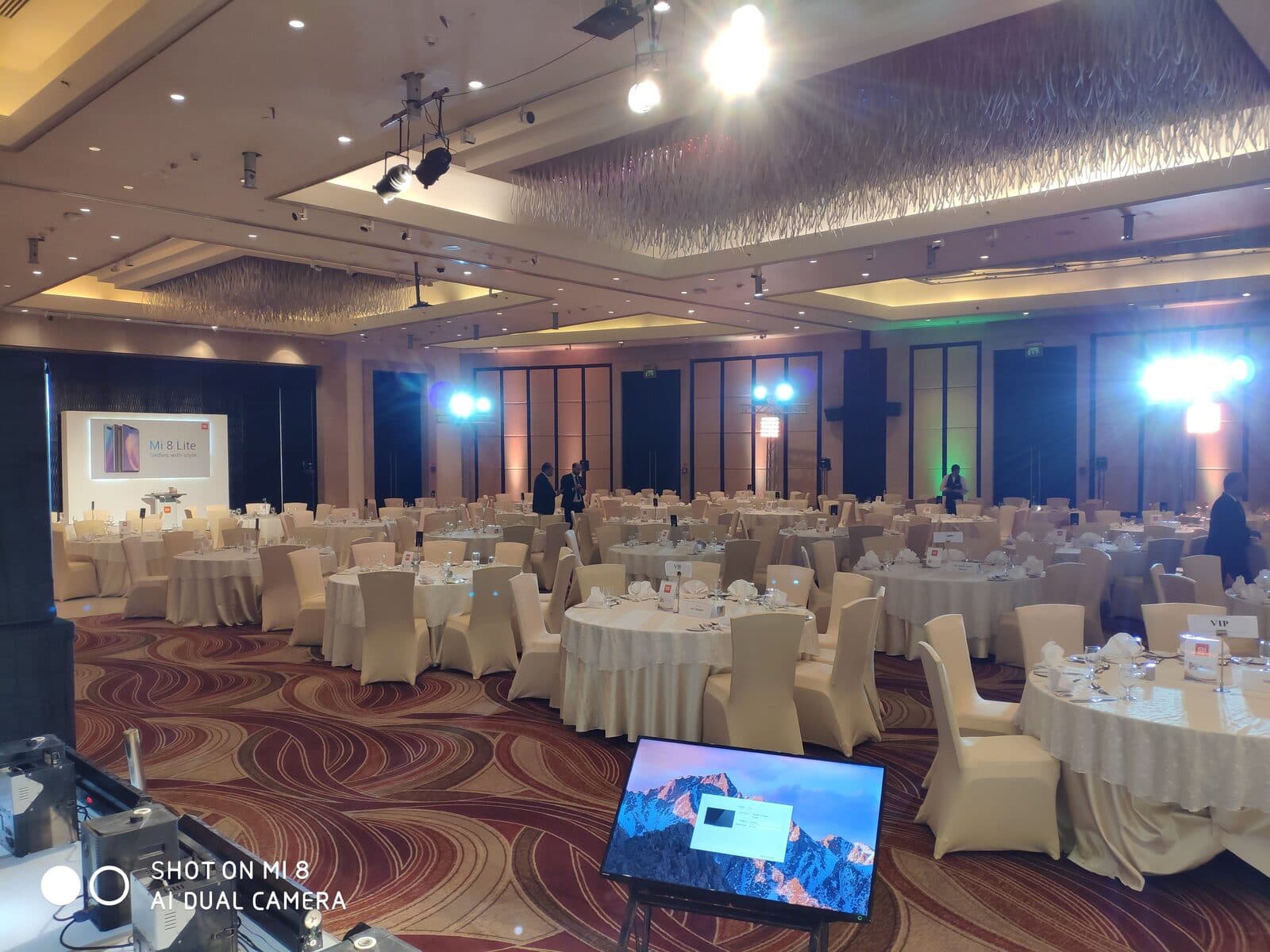 An empty ballroom with a launch screen reading 'Mi 8 Lite — Selfies with style, New Product Launch, Nov 13th 2018'